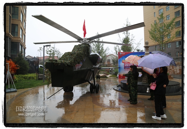 小區(qū)突然出現(xiàn)“飛機坦克”，其中殲15艦載戰(zhàn)斗機一架、99式主戰(zhàn)坦克一輛、武直-10武裝直升機一架，吸引了眾多市民雨中圍觀、合影。